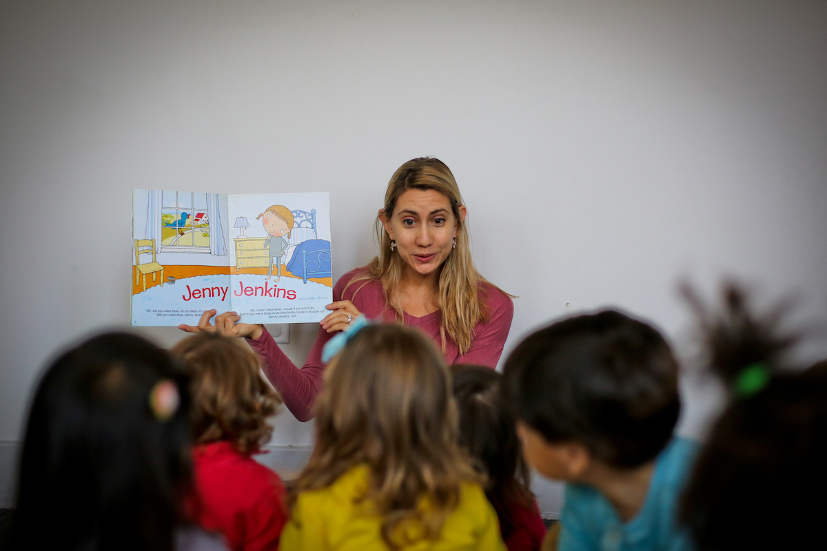 A Head Start Program teacher uses sing-song rhymes as she reads to her class. 