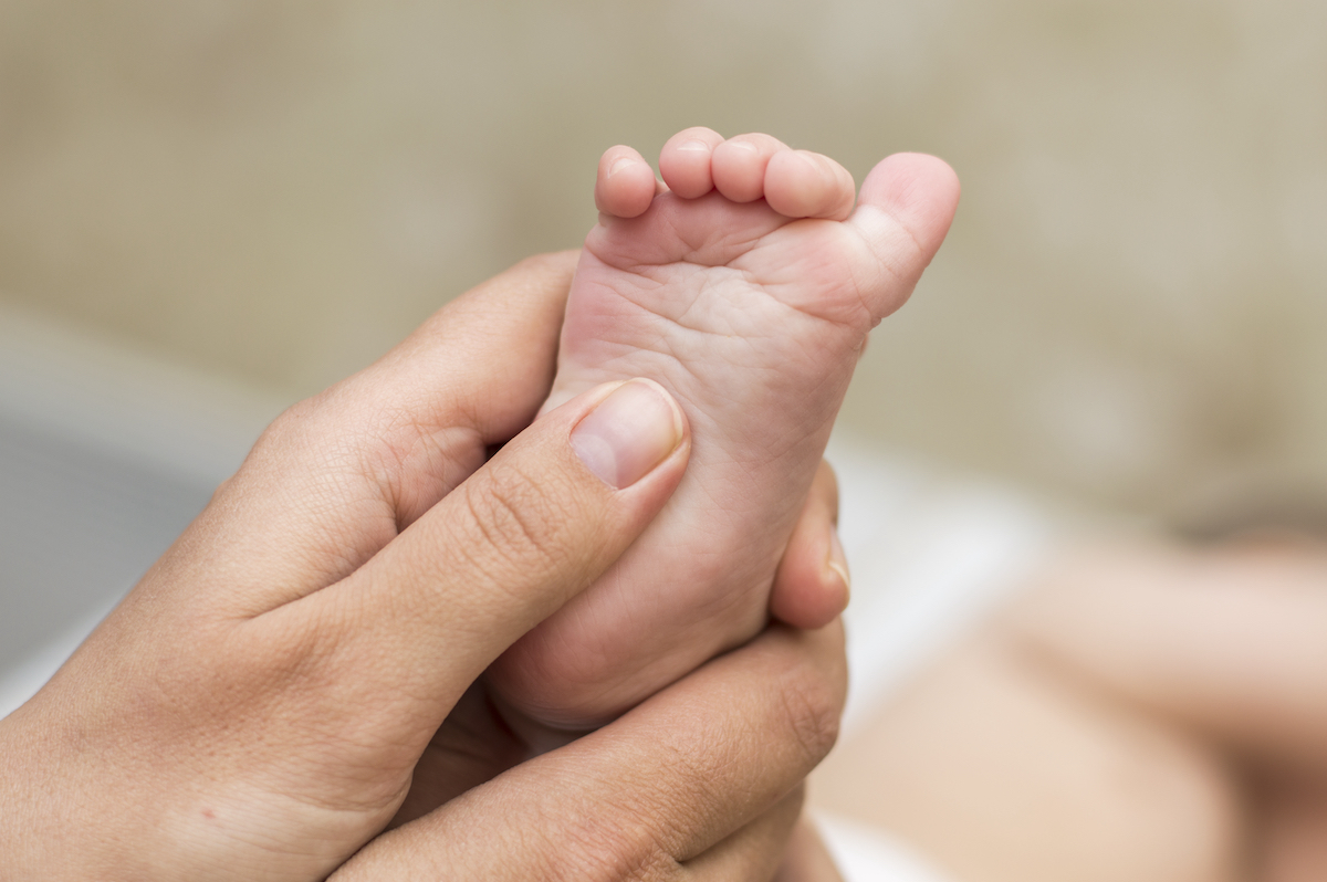 A mom uses a foot massage to help calm her baby and prevent meltdowns.