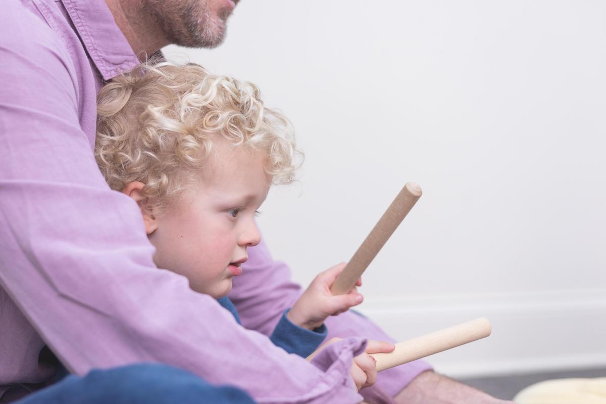 Father and son use sticks to tap to the beat. Tapping is one way to self-regulate.
