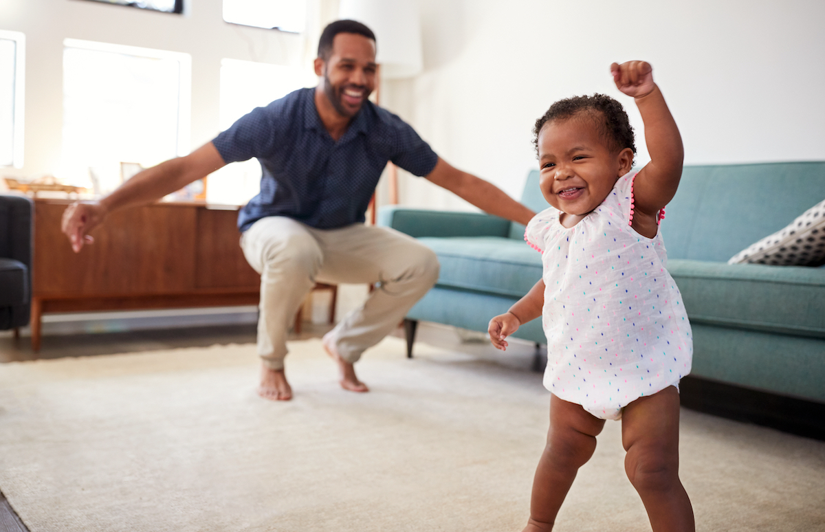 Father dances in time with his toddler daughter. Dancing in sync helps us self-regulate by opening communication and generating focus on one another.