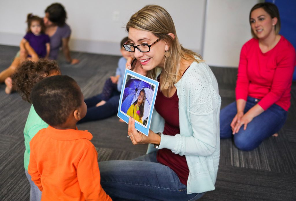 Kindermusik educator showing a visual to toddlers during Kindermusik class.