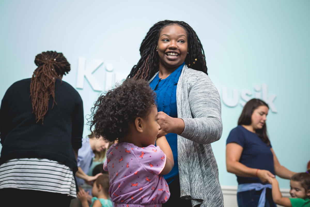 A mom dances and builds social-emotional growth with her daughter in a Kindermusik class.