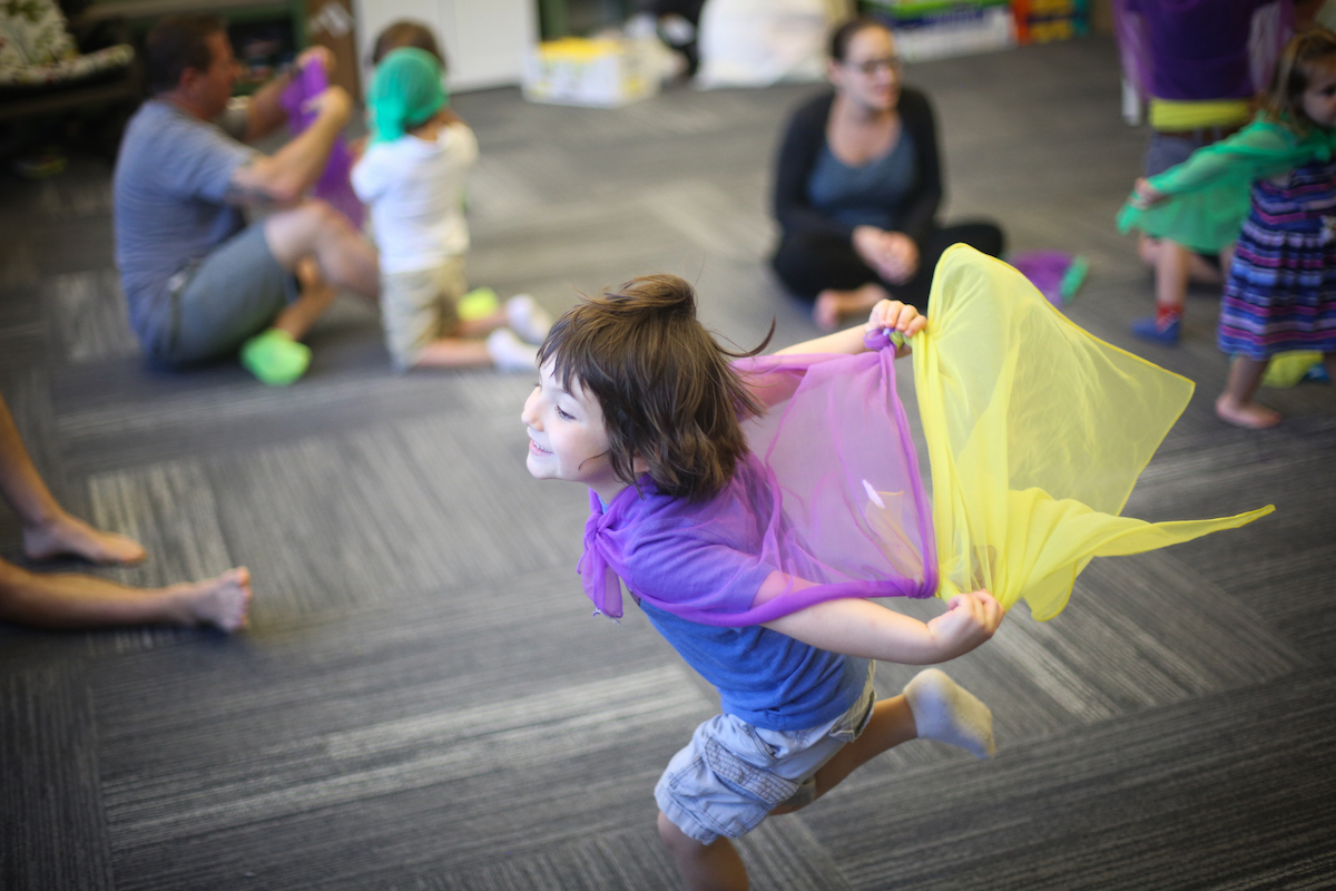 Child dances to music with scarves. Interpretive dance is an ideal multisensory outlet for neurodivergent learners.