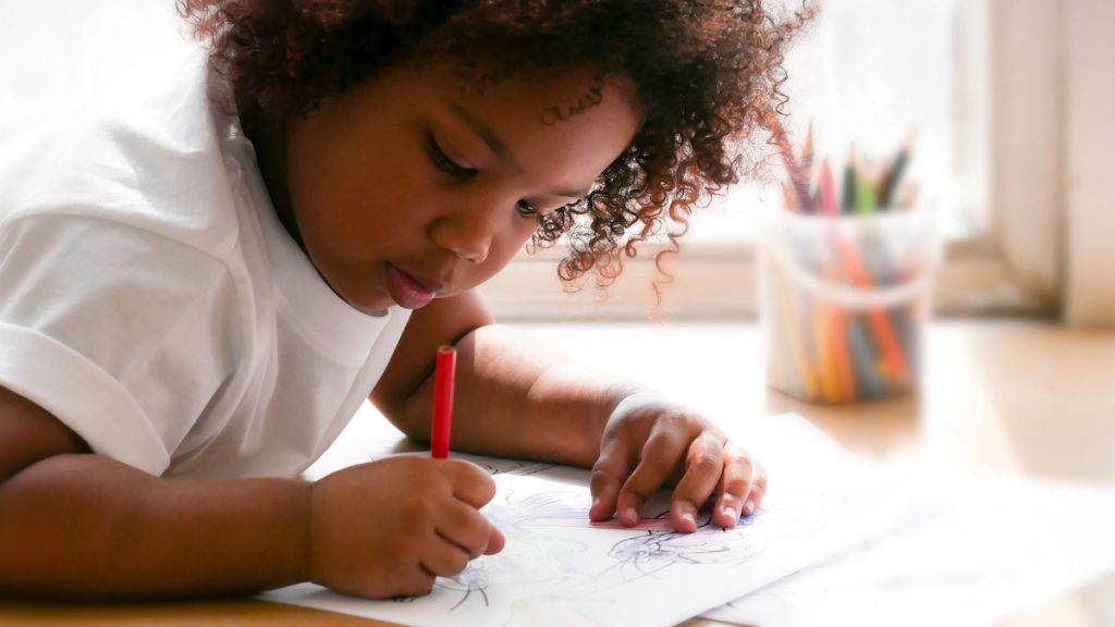 Preschooler draws on paper. Neurodivergent learners can safely express emotions by drawing what they hear.