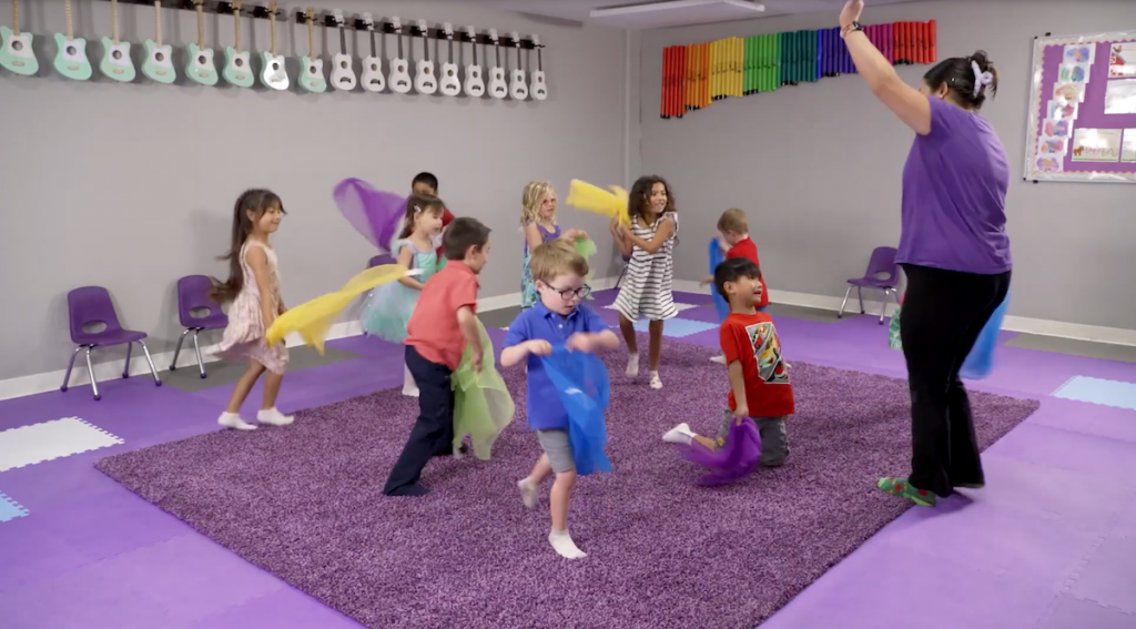 Preschoolers dance with sheer scarves in a Kindermusik Top Program class.