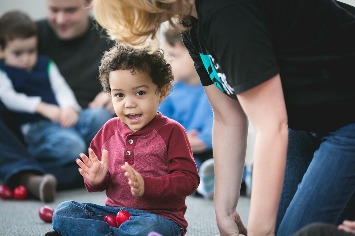 A 3-year-old boy claps to the beat during a Kindermusik class. Clapping is a foundational tool for early development.